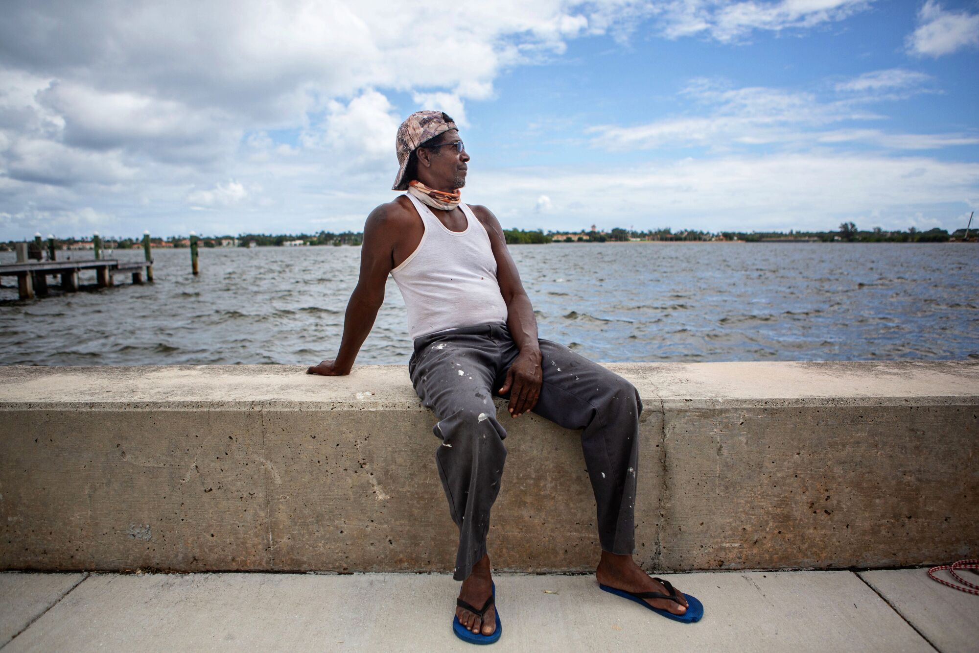 Milton Jackson sits on a low concrete wall next to the waterway along Palm Beach