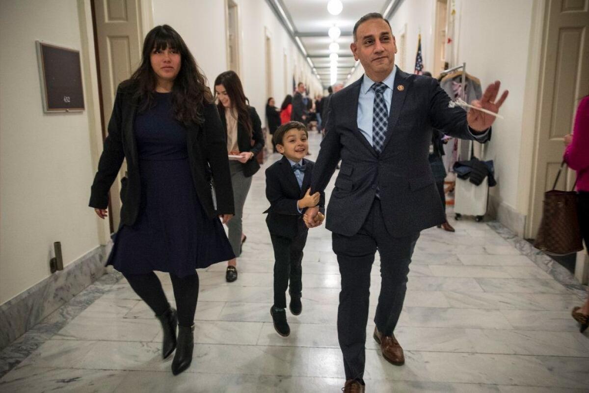 Gil Cisneros, a new member of congress from California, picture with aide Daphne Sigala, left and his son Christopher, makes the rounds on Capitol Hill on the day all members of new congress were sworn in. David Butow/for the Times