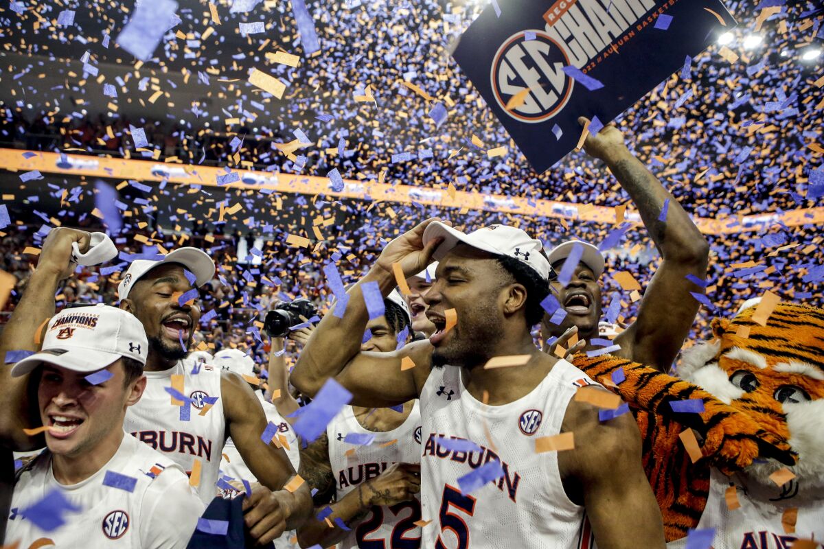 Auburn players celebrates winning the Southeastern Conference regular season championship after an NCAA college basketball game against South Carolina, Saturday, March 5, 2022, in Auburn, Ala. (AP Photo/Butch Dill)