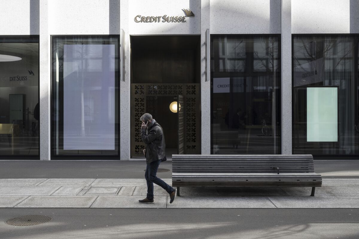 People walk past the entrance of Swiss bank Credit Suisse in Zurich, Switzerland, Thursday, March 16, 2023. Credit Suisse is borrowing up to 50 billion francs from the Swiss National Bank (SNB), according to a statement on Thursday, 16 March 2023. This is intended to strengthen the group, whose shares have crashed on the stock exchange. (Ennio Leanza/Keystone via AP)