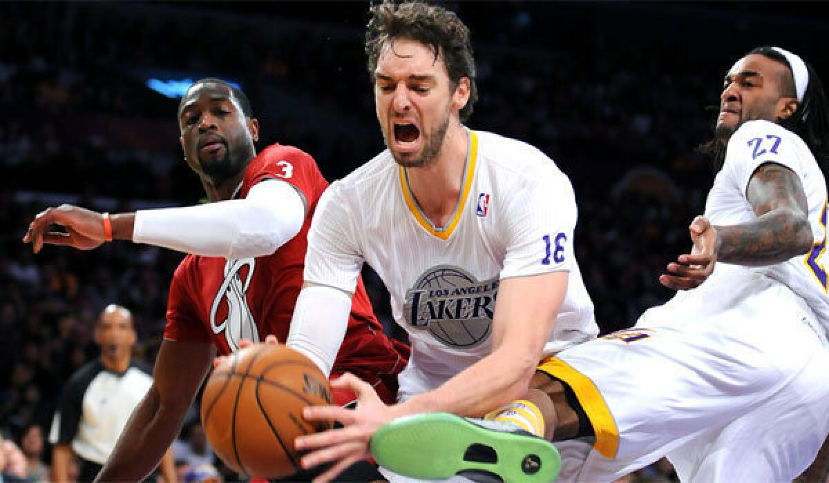 Pau Gasol is fouled by Miami's Dwayne Wade, left, as Jordan Hill (27) falls away at Staples Center on Wednesday.