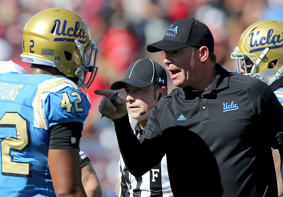 UCLA Coach Jim Mora talks with linebacker Kenny Young during the game against Utah on Oct. 22 at the Rose Bowl.