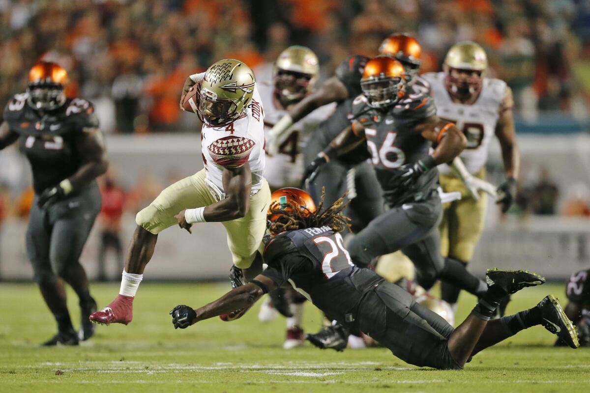 Florida State's Dalvin Cook runs past Miami's Nantambu-Akil Fentress to score the winning touchdown Saturday at Sun Life Stadium.