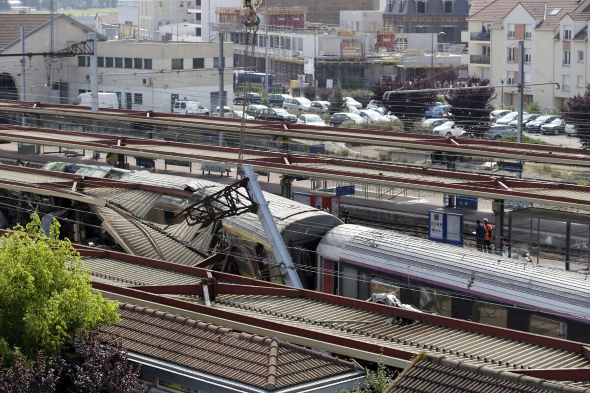 Crumpled cars remain at the site of a train accident in Bretigny-sur-Orge, France, which killed at least six people.