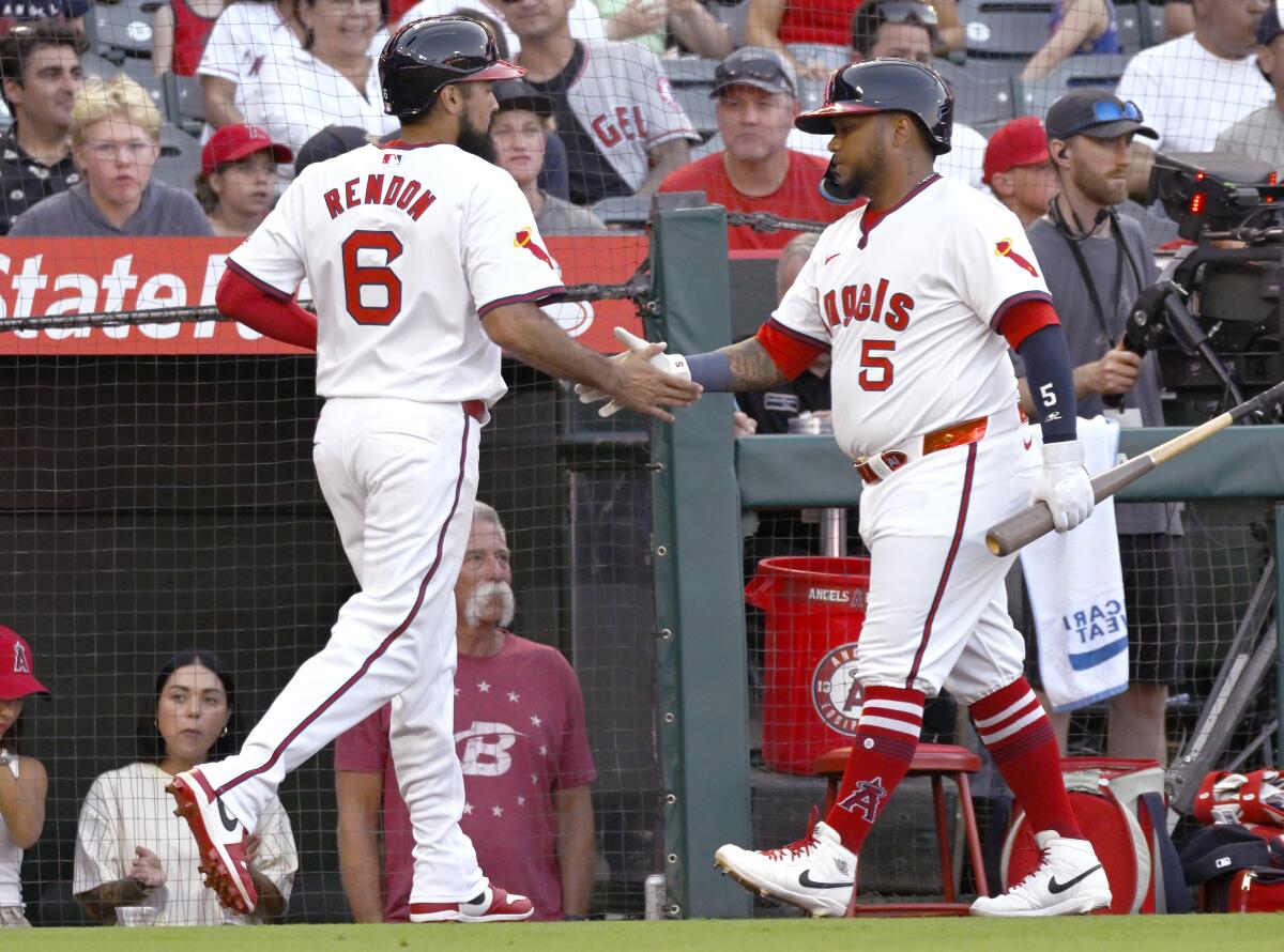 The Angels’ Anthony Rendon is congratulated by Willie Calhoun after being driven in on a double