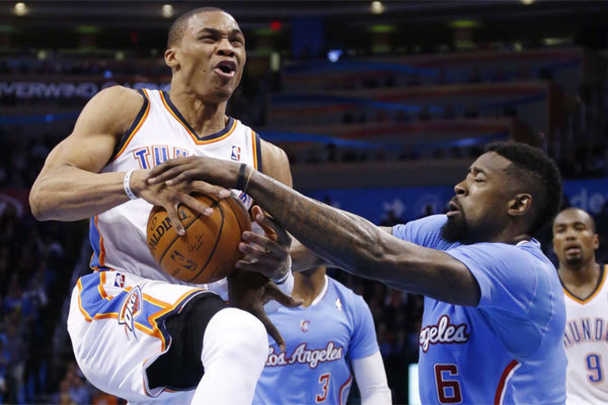 Clippers center DeAndre Jordan attempts to take the ball from Oklahoma City guard Russell Westbrook in the teams' last meeting on Feb. 23 in Oklahoma City. The Clippers won, 125-117.