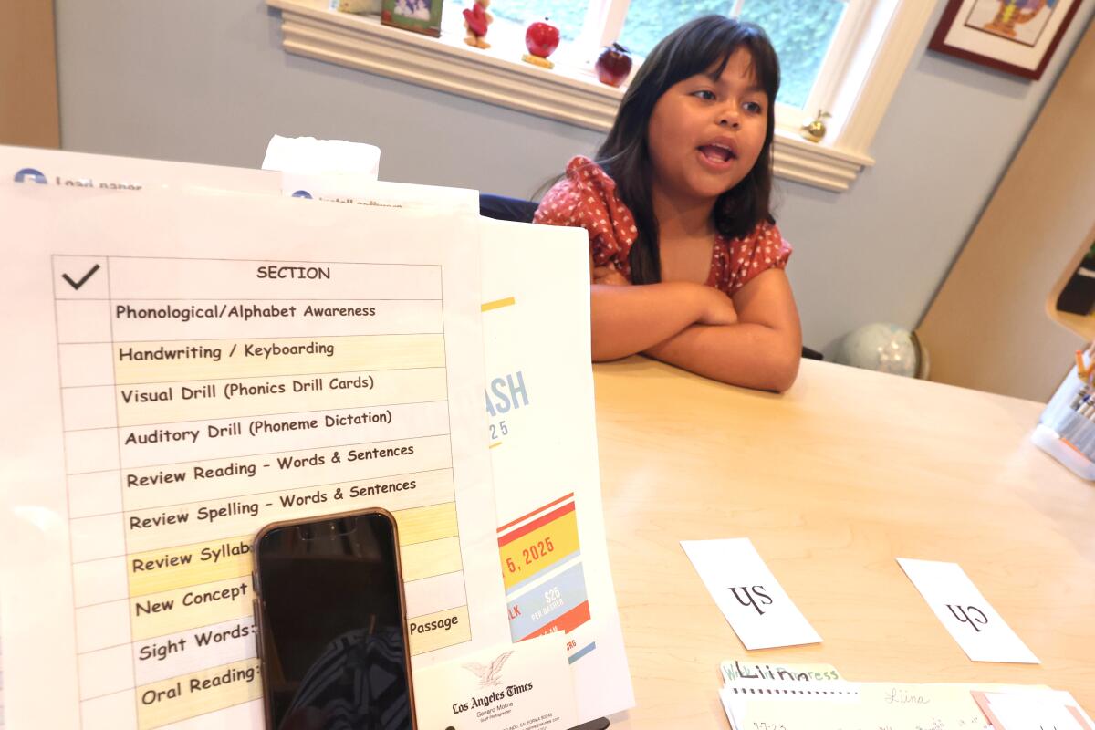 Lina Yero, 9, trabalha em uma prática de encantamento em sua mesa.