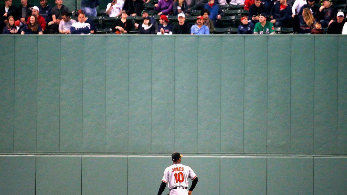 The Baltimore Orioles' Adam Jones looks up at fans in center field during the third inning against the Boston Red Sox on April 2.