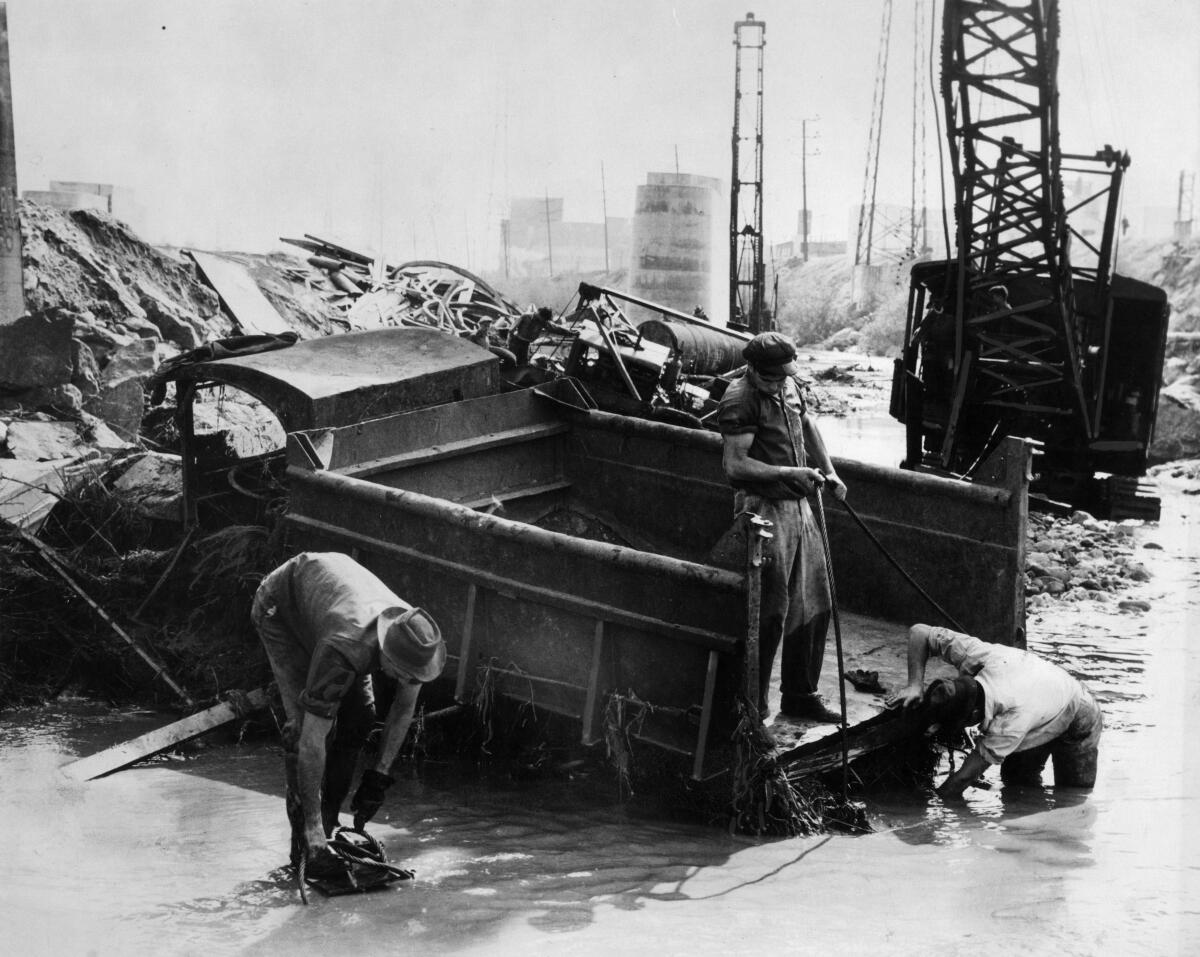Salvage crew tries to dig out gravel truck damaged by flooding along the Los Angeles River on March 2, 1938. 