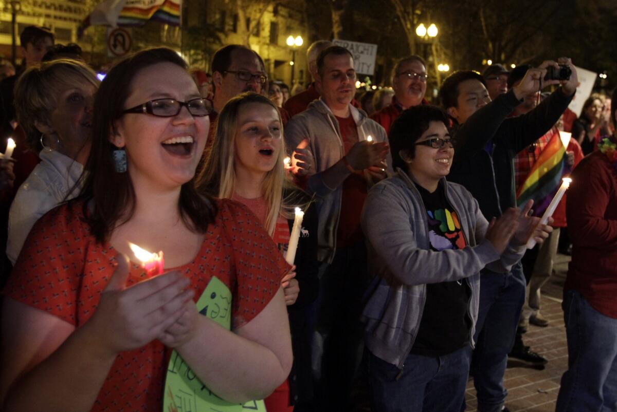 Jessica Christensen, left, celebrates with others during a candlelight vigil held by supporters of same-sex marriage at the Ronald Reagan Federal Building and U.S. Courthouse in Santa Ana.