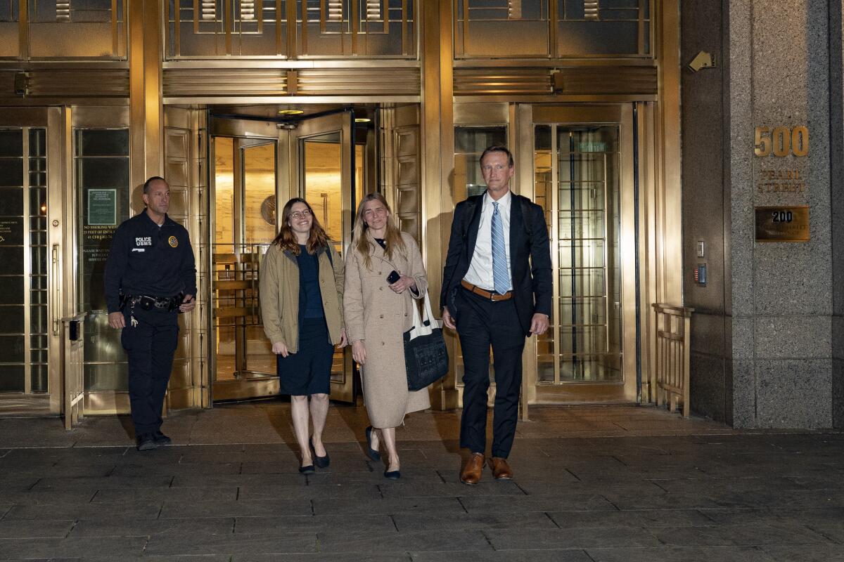 Robert De Niro walks away from federal court in a mask, a blue blazer and a gray shirt next to a man on a cellphone