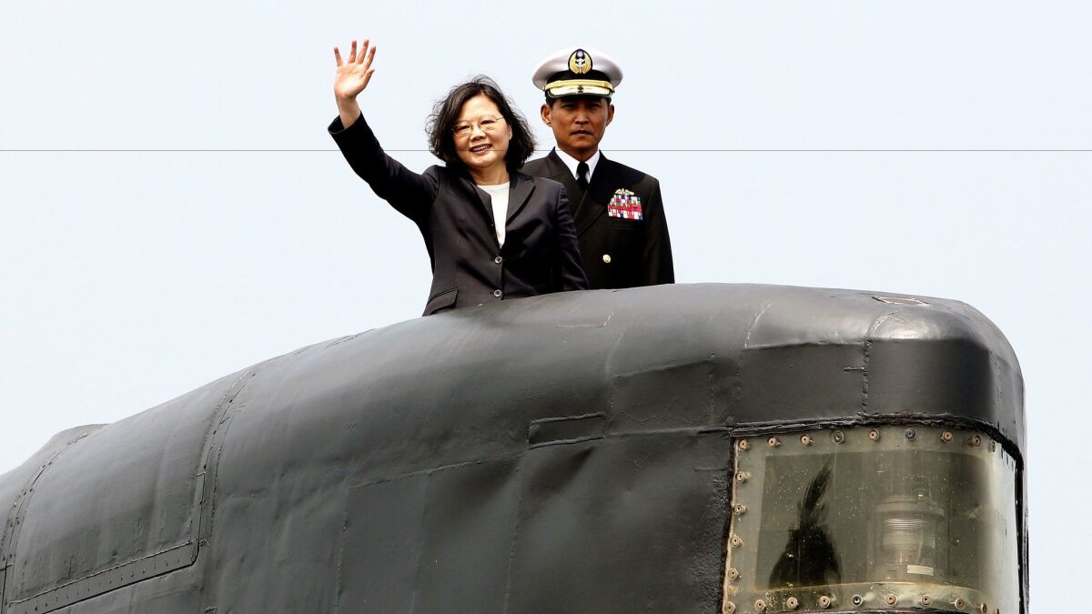 Taiwanese President Tsai Ing-wen, left, waves from a Zwaardvis-class submarine during a visit at Zuoying naval base in Kaohsiung, southern Taiwan, on March 21, 2017.