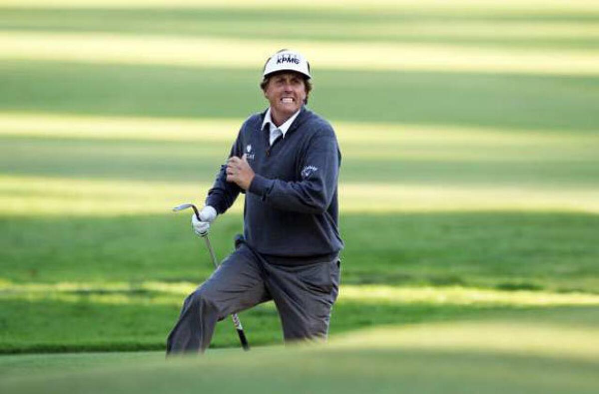 Phil Mickelson runs from the front bunker to see where his shot landed on the 10th hole on Friday.