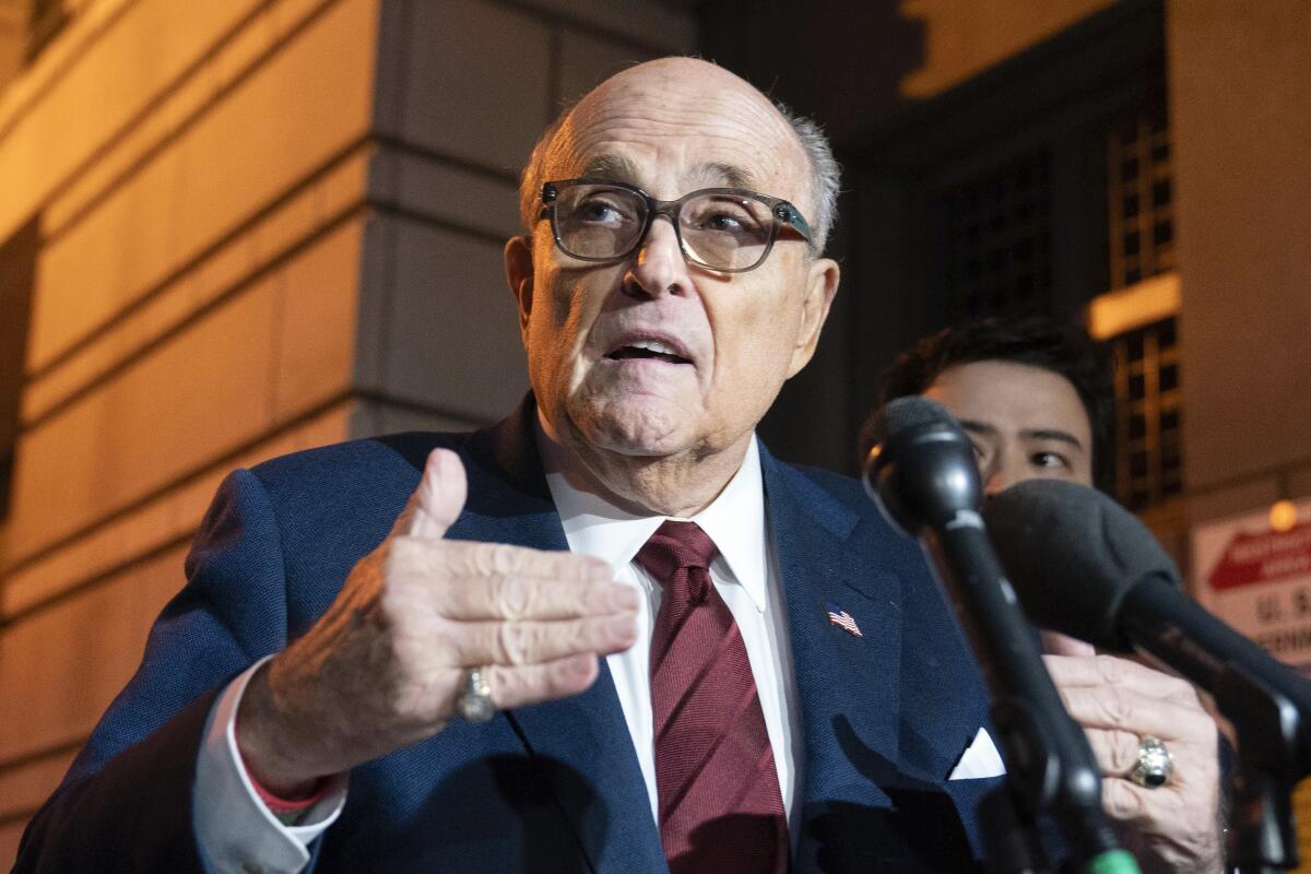 Rudolph W. Giuliani speaks into microphones.