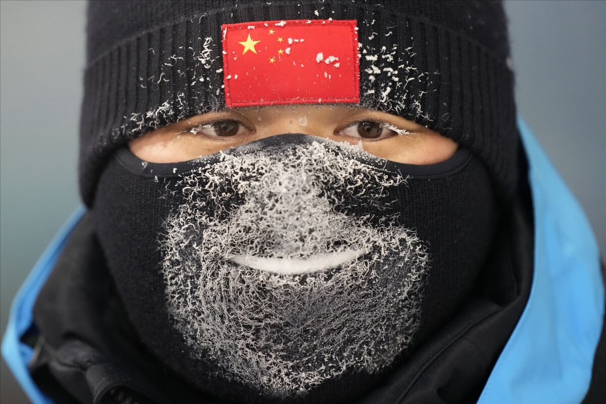 A police officer stands guard during the women's aerials finals at the 2022 Winter Olympics, Monday, Feb. 14, 2022, in Zhangjiakou, China. (AP Photo/Lee Jin-man)