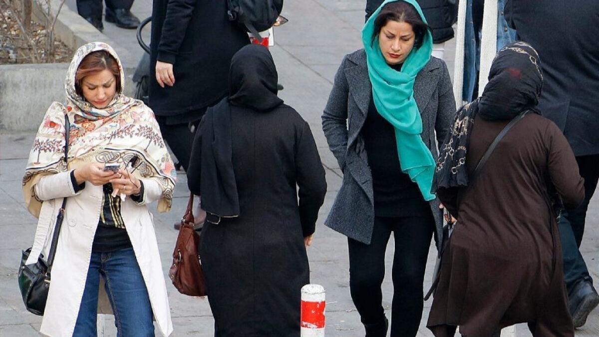 Iranian women wearing the hijab, or headscarf, walk down a street in Tehran on Feb. 7.