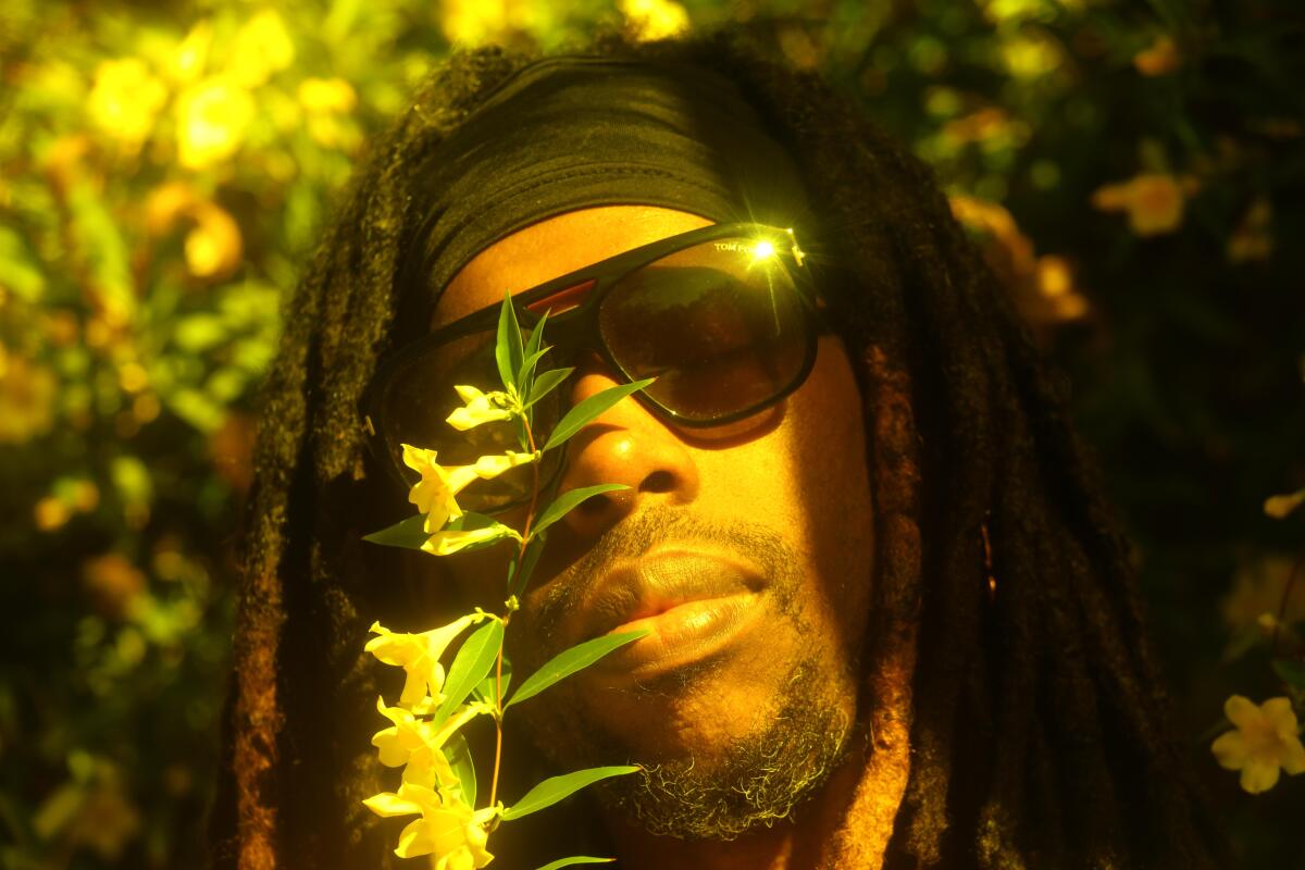 Producer is photographed alongside flowers.