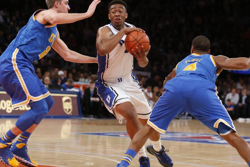 Duke's Jabari Parker, center, drives between UCLA's Travis Wear, left, and Norman Powell during the first half of Thursday's game at Madison Square Garden in New York.