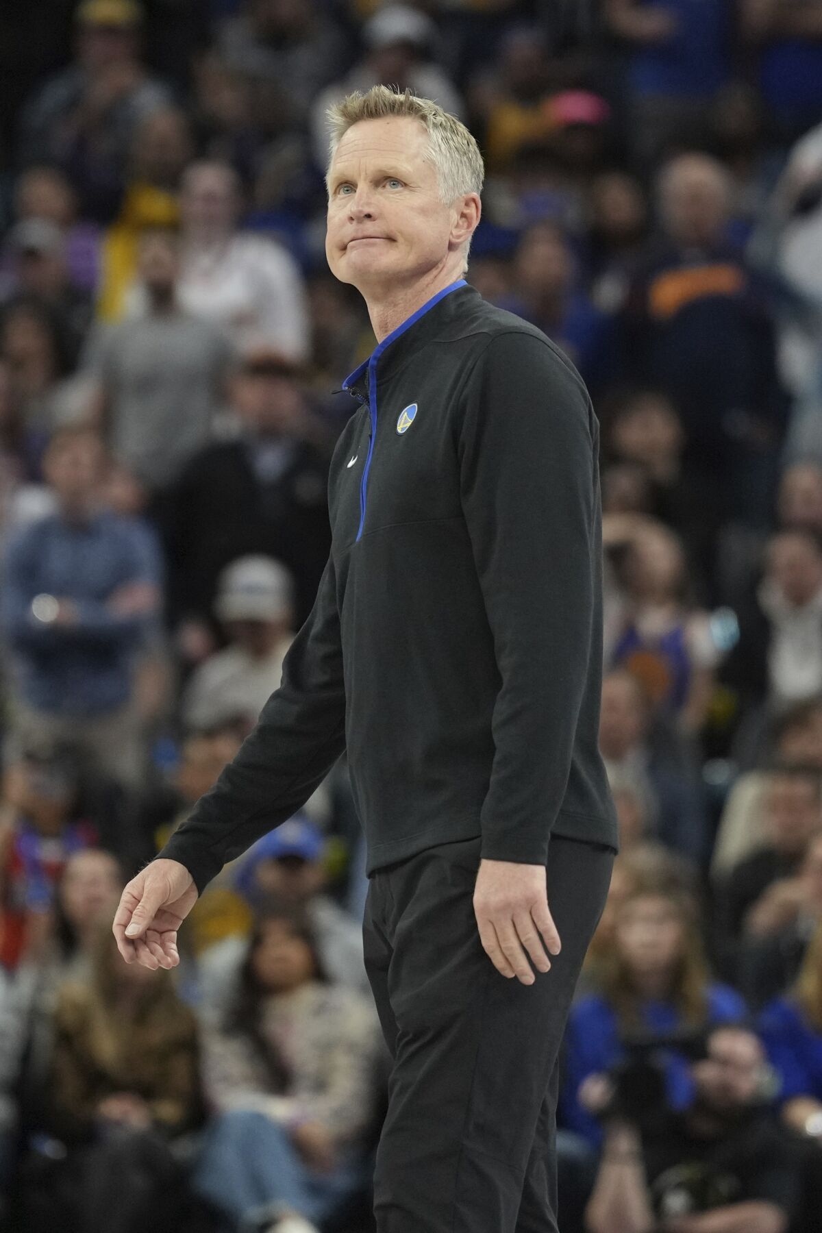 Golden State Warriors coach Steve Kerr watches play as he stands on the sideline.