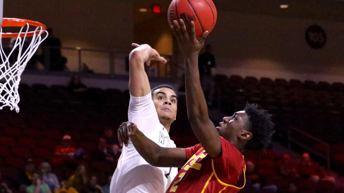 USC guard Jonah Mathews has his layup contested by Wyoming guard Justin James in the first half of the Las Vegas Classic championship game on Friday night.