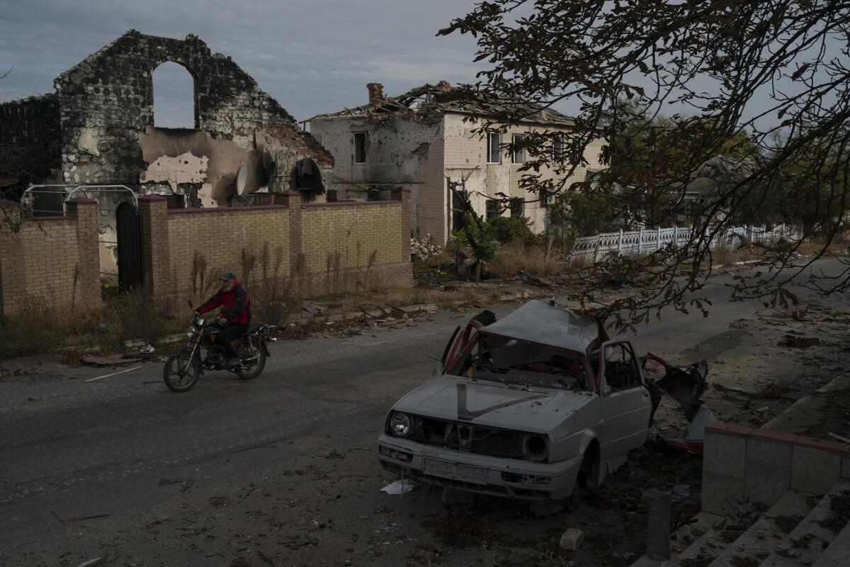Destroyed car and buildings in recaptured Ukrainian village