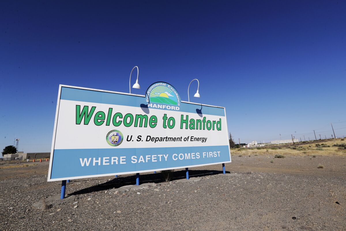 FILE - A sign at the Hanford Nuclear Reservation is posted near Richland, Wash., on Aug. 14, 2019. Workers at the Hanford Nuclear Reservation have started the first large-scale treatment of radioactive and chemical wastes from large underground storage tanks, a key milestone in cleaning up the site. (AP Photo/Elaine Thompson, File)