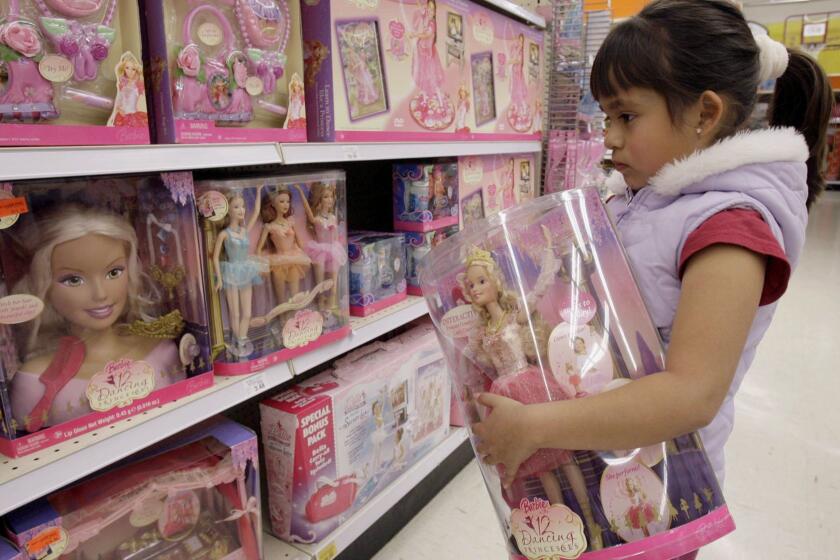 FILE- In this Jan. 29, 2007, file photo Yvette Ibarra holds a Dancing Princess Barbie doll while shopping at a Toys R us in Monrovia, Calif. Toys R Us CEO David Brandon told employees Wednesday, March 14, 2018, that the company's plan is to liquidate all of its U.S. stores, according to an audio recording of the meeting obtained by The Associated Press. (AP Photo/Nick Ut, File)