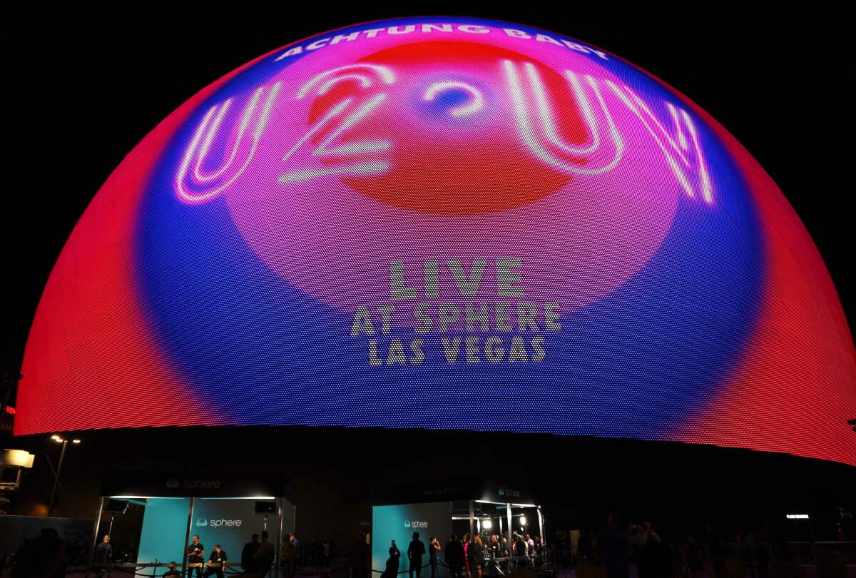 The outside of Sphere says 'U2 UV Live at Sphere Las Vegas in concentric circles of red, pink, and blue.