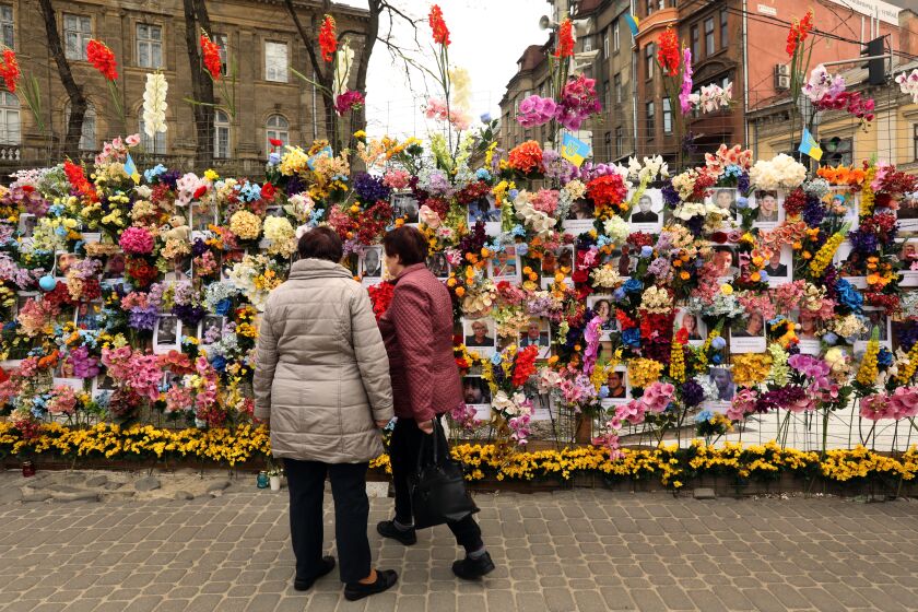 Lviv, Ukraine-April 30, 2022-A memorial to those have lost their lives in the Russian war on Ukraine is visited by people in downtown Lviv on Saturday, April 30, 2022. Many Ukrainians enjoyed the spring weather on Saturday, April 30, 2022, in Lviv, where life is relatively normal despite the war in the east. (Carolyn Cole / Los Angeles Times)