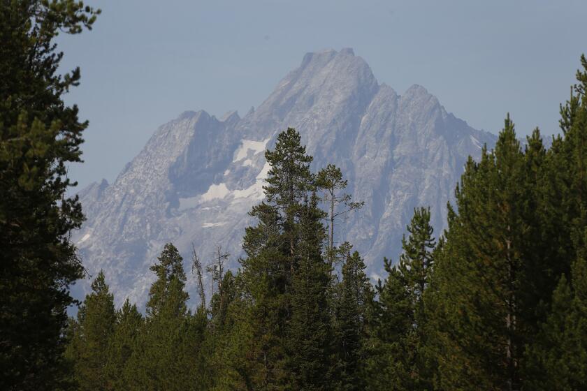 The morning sun illuminates the Grand Tetons, in Grand Teton National Park, Wyo., Saturday, Aug 27, 2016. Park activities continue despite wildfires just north of Coulter Bay and in Yellowstone which have closed Teton's north entrance and the south entrance to Yellowstone National Park. (AP Photo/Brennan Linsley)