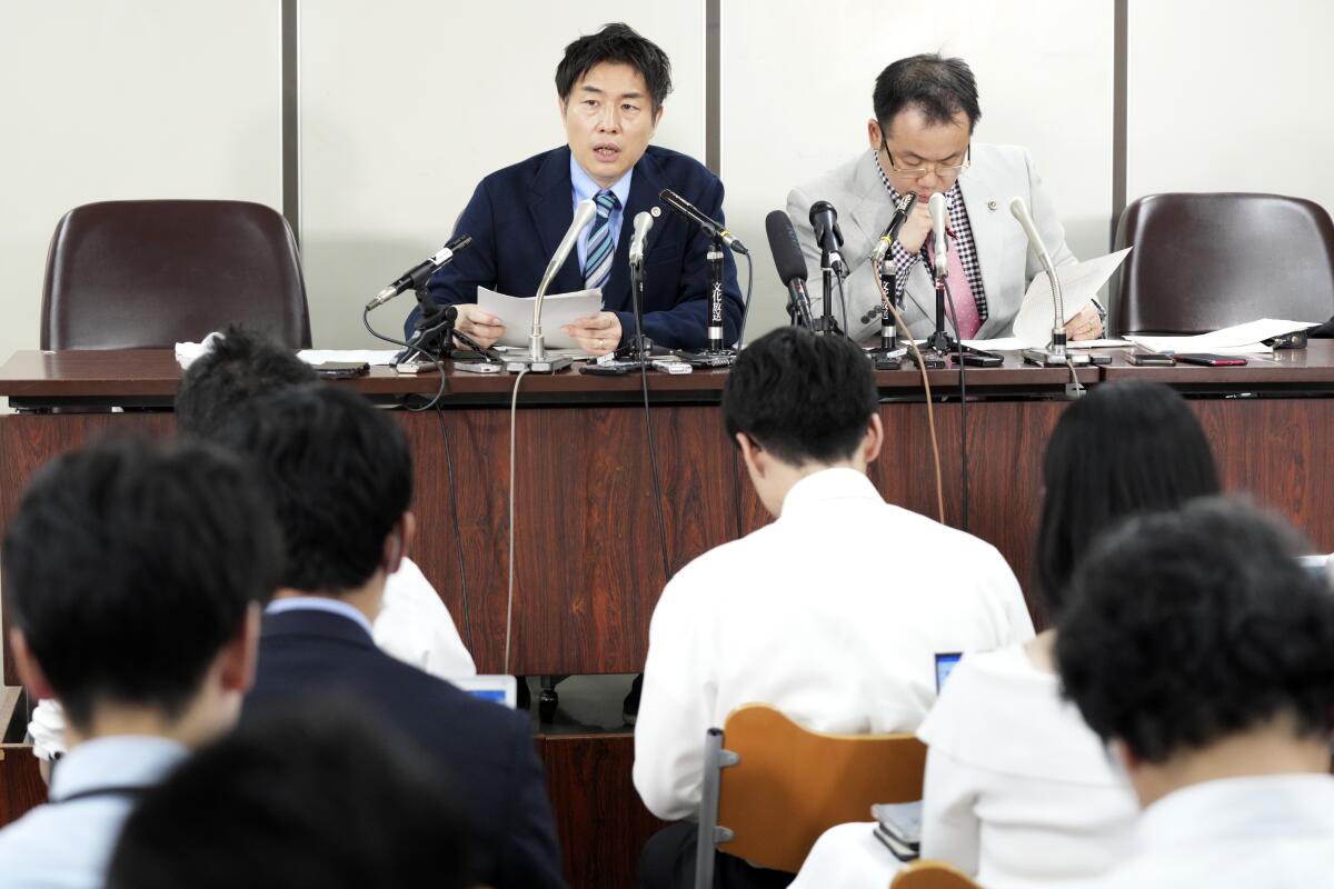 Lawyers of a claimant, Kazuyuki Minami, left, and Masafumi Yoshida, right, speak to media.