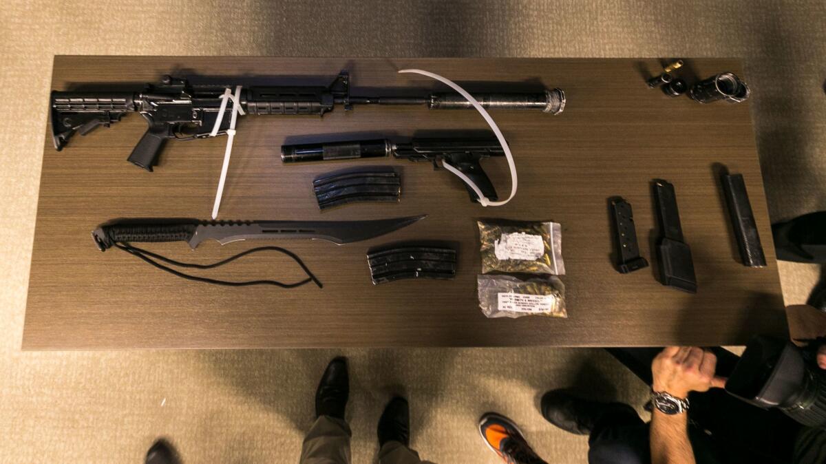 Los Angeles County Sheriff's Department deputies show a cache of illegal arms found in a suspect's duffel bag after arresting him Wednesday at a Pasadena Metro station.