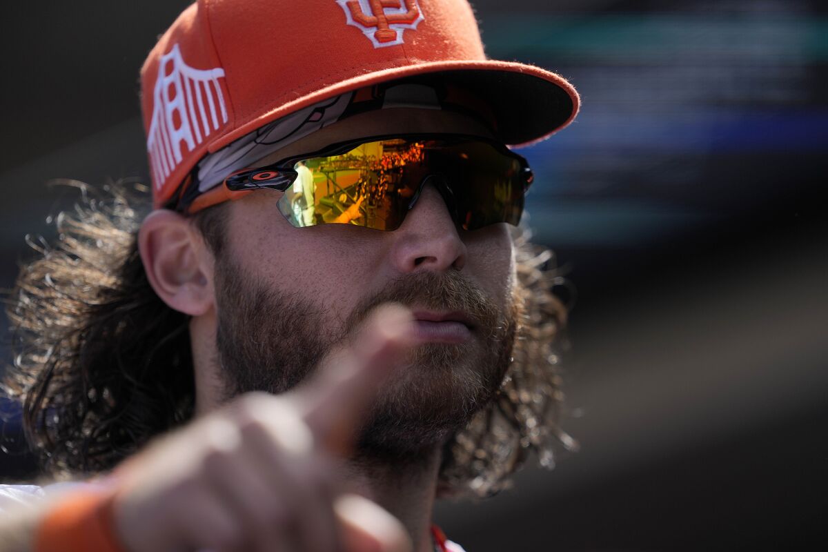 San Francisco Giants shortstop Brandon Crawford points to fans as he walks into the dugout after a victory over the Washington Nationals in a baseball game Sunday, July 11, 2021, in San Francisco. (AP Photo/Tony Avelar)