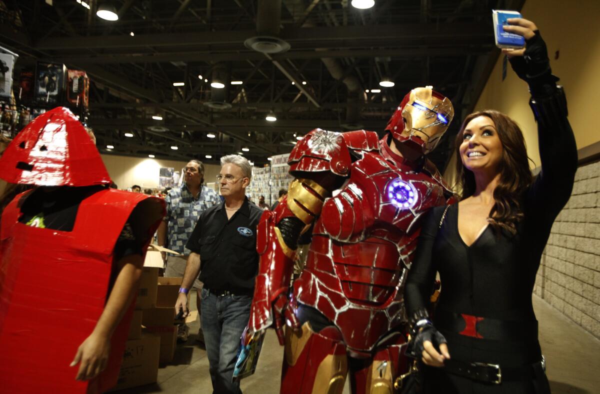 Nikki Steel, left, como Black Widow, se toma un selfie con Jerry Powell, disfrazado de Iron Man, durante la Long Beach ComicCon del 2014.