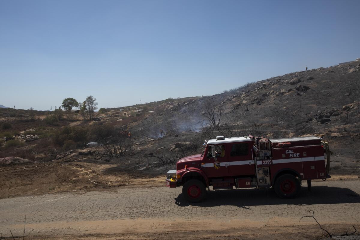 Fire crews work to put out a brush fire that burned about 50 acres on Monday, Sept. 5, 2022 in Ramona.