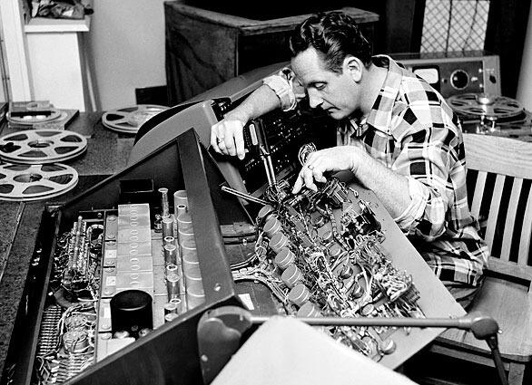 FILE - In this Dec. 20, 1963 file photo, Les Paul repairs one of the many control boards in the control room at his Oakland, N.J., home. Paul, 94, the guitarist and inventor who changed the course of music with the electric guitar and multitrack recording and had a string of hits, died, Thursday, Aug. 13, 2009 in White Plains, N.Y., according to Gibson Guitar. (AP Photo/Dan Grossi, file)