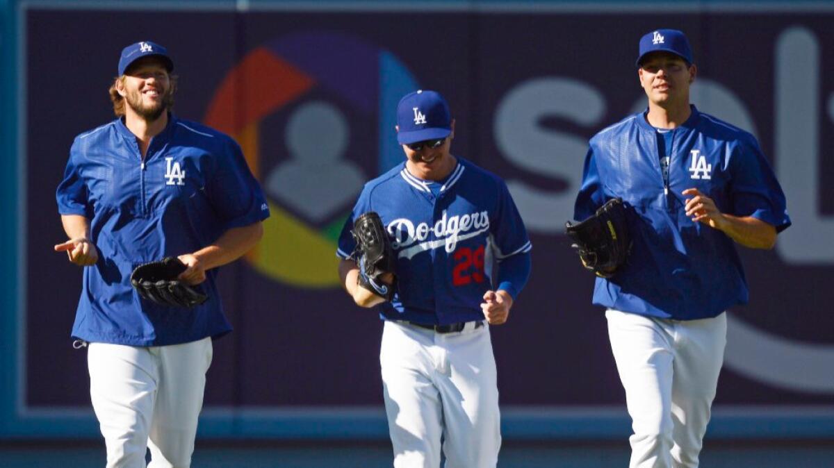 Dodgers pitchers Clayton Kershaw, Scott Kazmir and Rich Hill jog together before a game against the Phillies on Aug. 9.