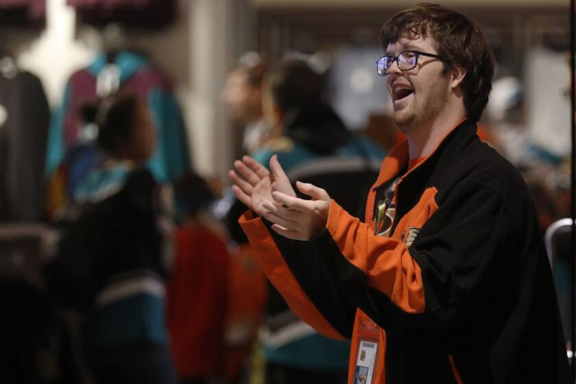 Anaheim, CA November 18, 2018: Trevor Hendershot, 28, joyfully stands outside the Ducks' team store at Honda Center in Anaheim, CA November 18, 2018. Trevor has Down Syndrome and works as a greeter for the Ducks, Rams and Angels. (Francine Orr/ Los Angeles Times)