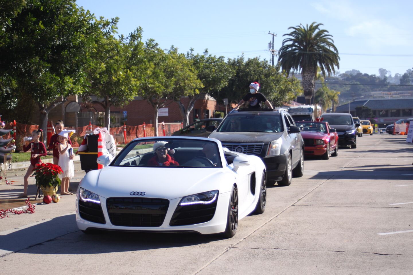 Cars proceed up Herschel Avenue to view La Jolla Christmas Parade floats stationed along the street.