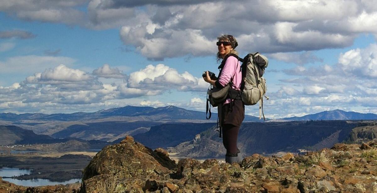 Author and Karen Sykes, 70, of Seattle, stands at an overlook near Grand Coulee, Wash.