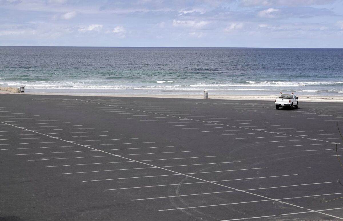 A single lifeguard truck is the only vehicle in a closed parking lot at Seaside Reef in Cardiff on April 5.