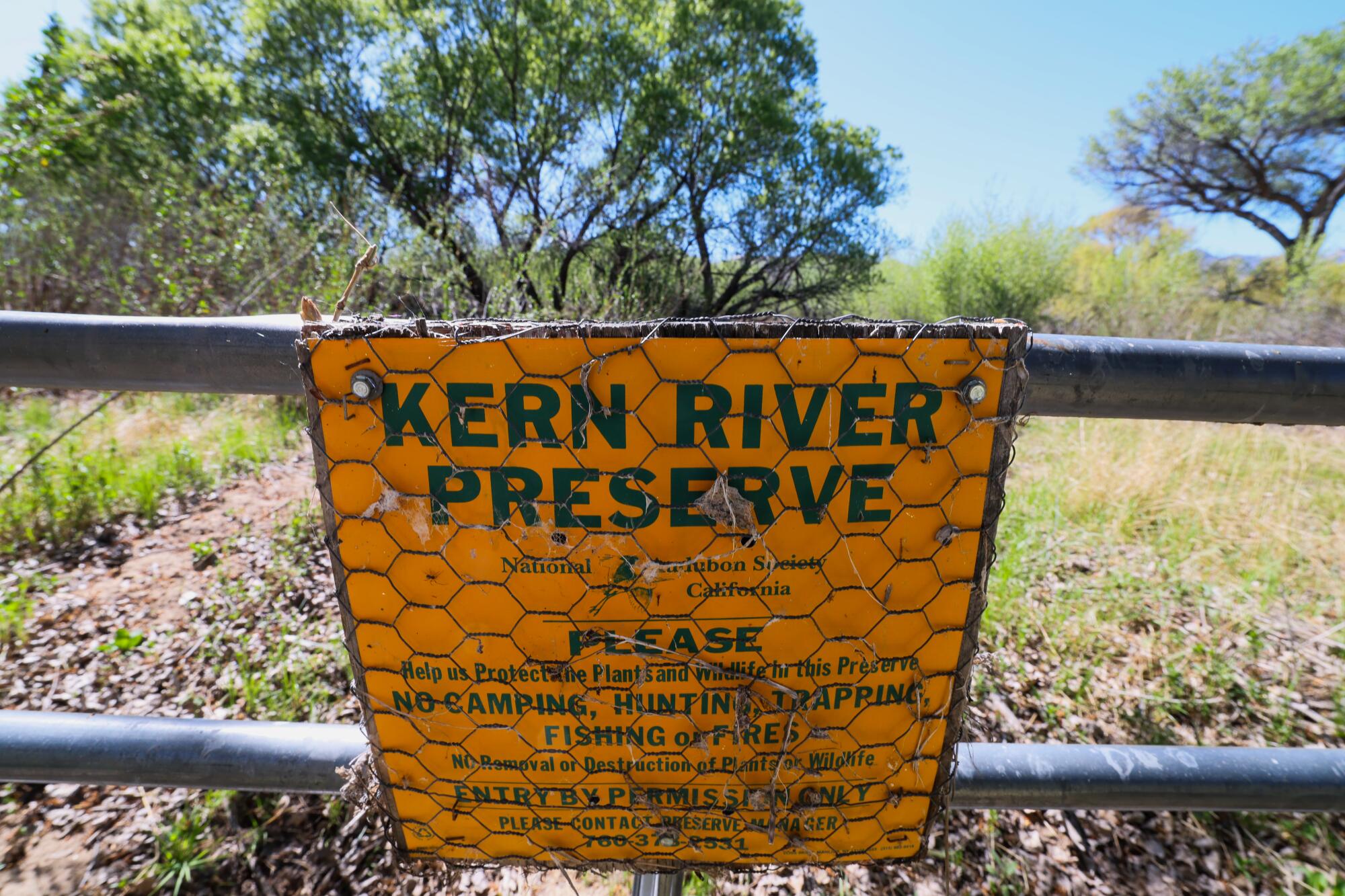 A sign reads "Kern River Preserve" on a gate, with trees in the background.