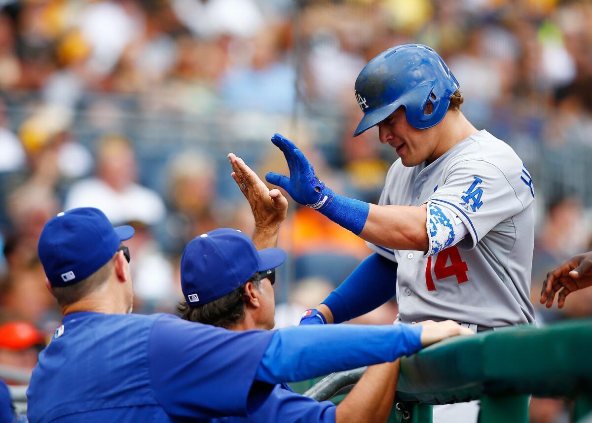 Dodgers center fielder Enrique Hernandez is congratulated by teammates in the dugout after hitting a two-run home run against the Pirates in the third inning Saturday.