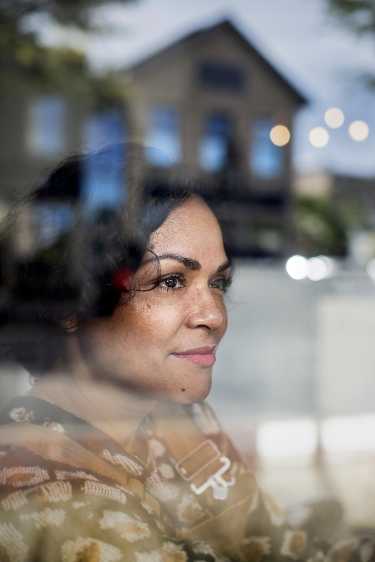 A portrait of Karen Olivo through clear glass.