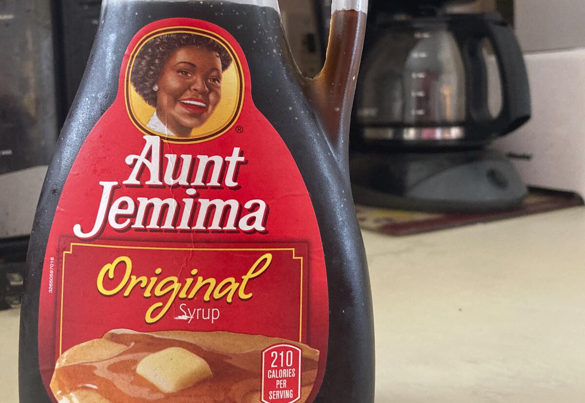 A bottle of Aunt Jemima syrup sits on a counter.