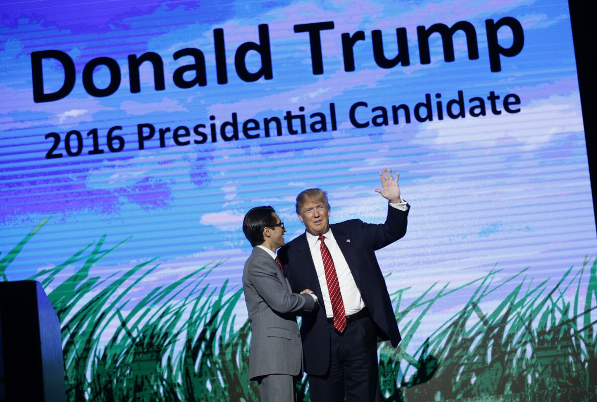 El magnate Donald Trump, derecha, aspirante a la candidatura republicana a la presidencia, saluda desde el escenario del Freedomfest, el sábado 11 de julio de 2015, en Las Vegas. (Foto AP/John Locher)
