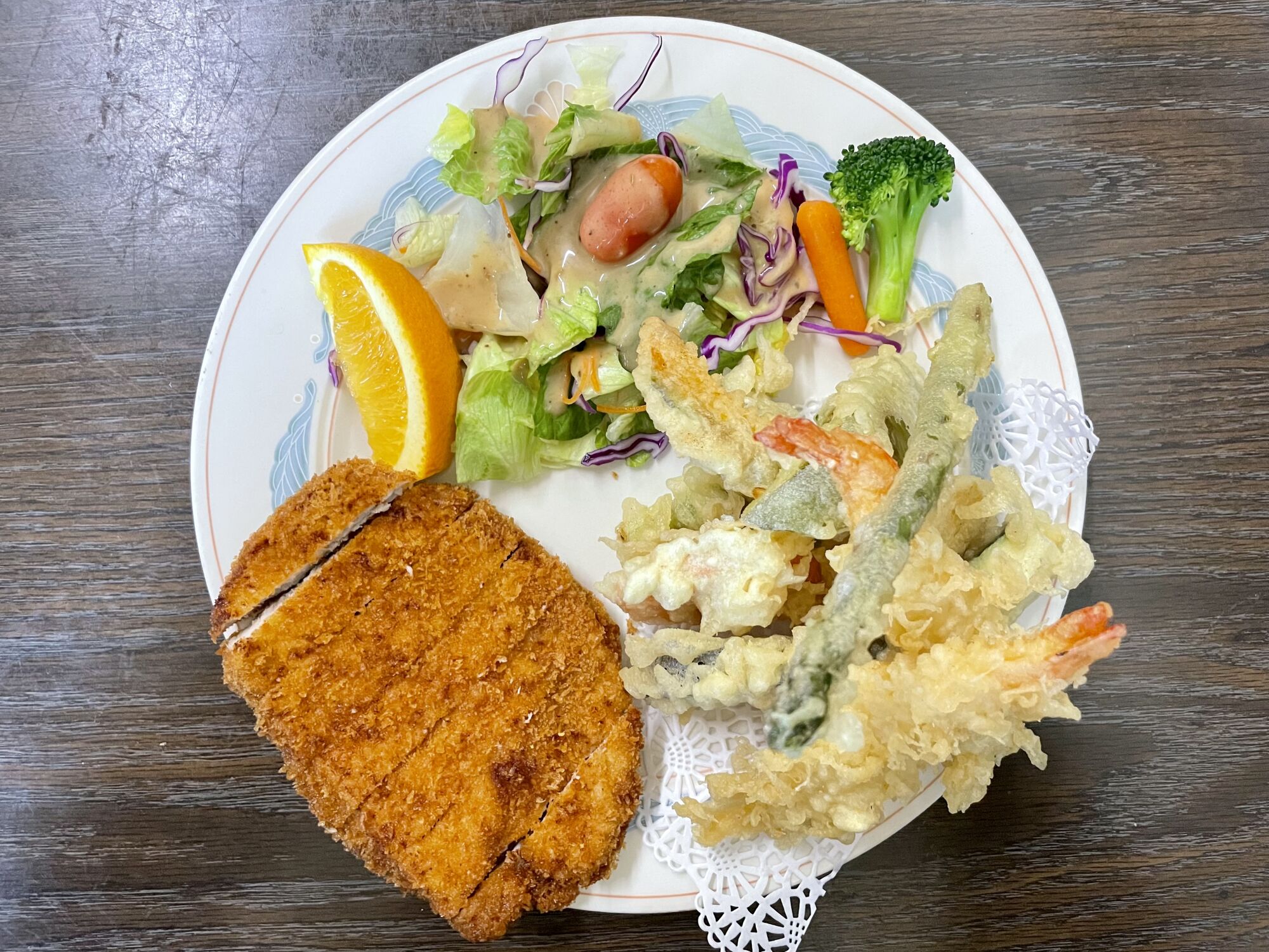 Pork katsu, tempura vegetables and salad on a combination plate.