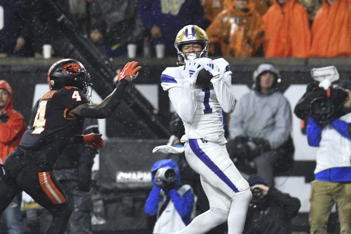 Washington's Rome Odunze (1) catches a pass for a touchdown as Oregon State defensive back Jaden Robinson (4) pursues.
