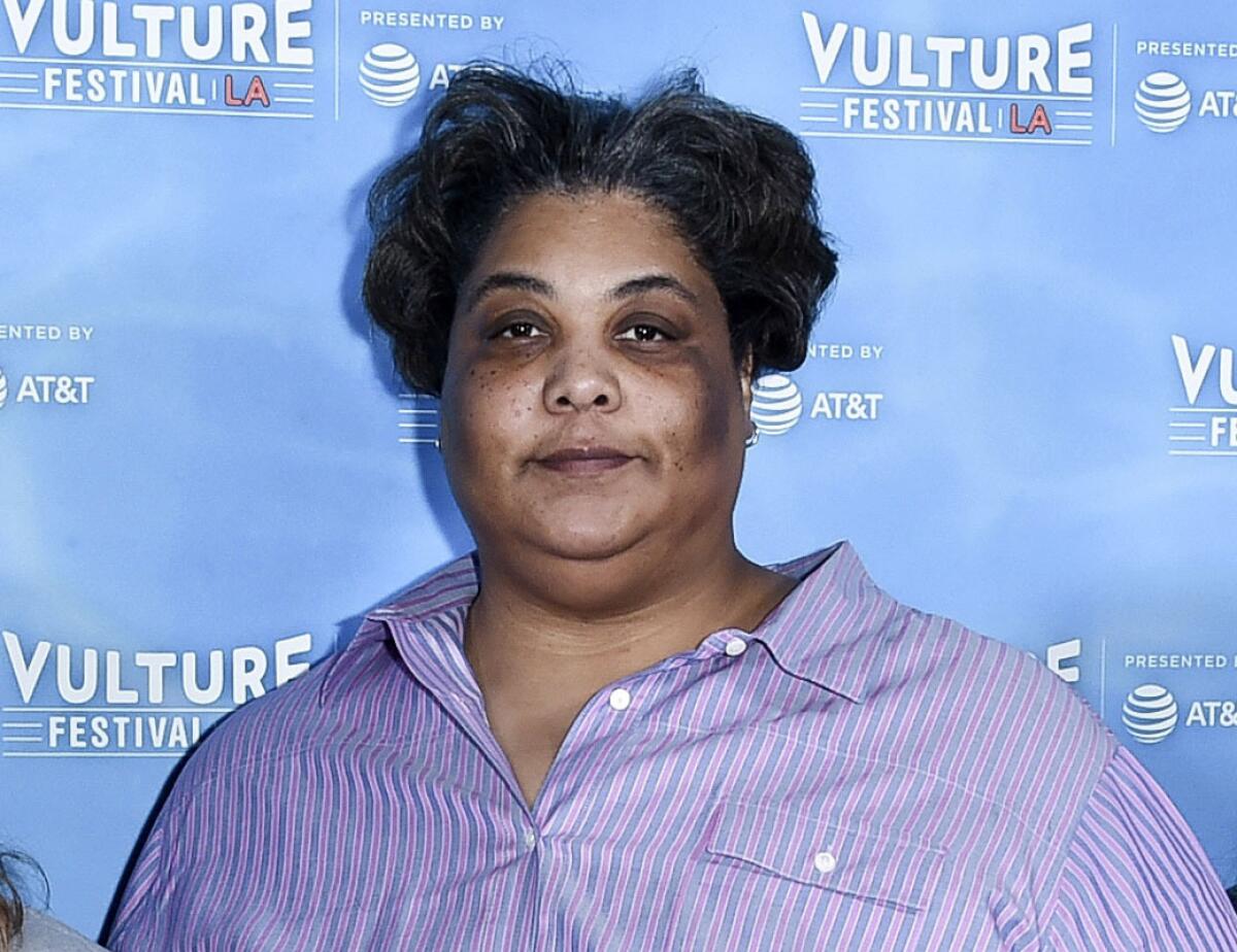 Roxane Gay posing in a purple shirt.