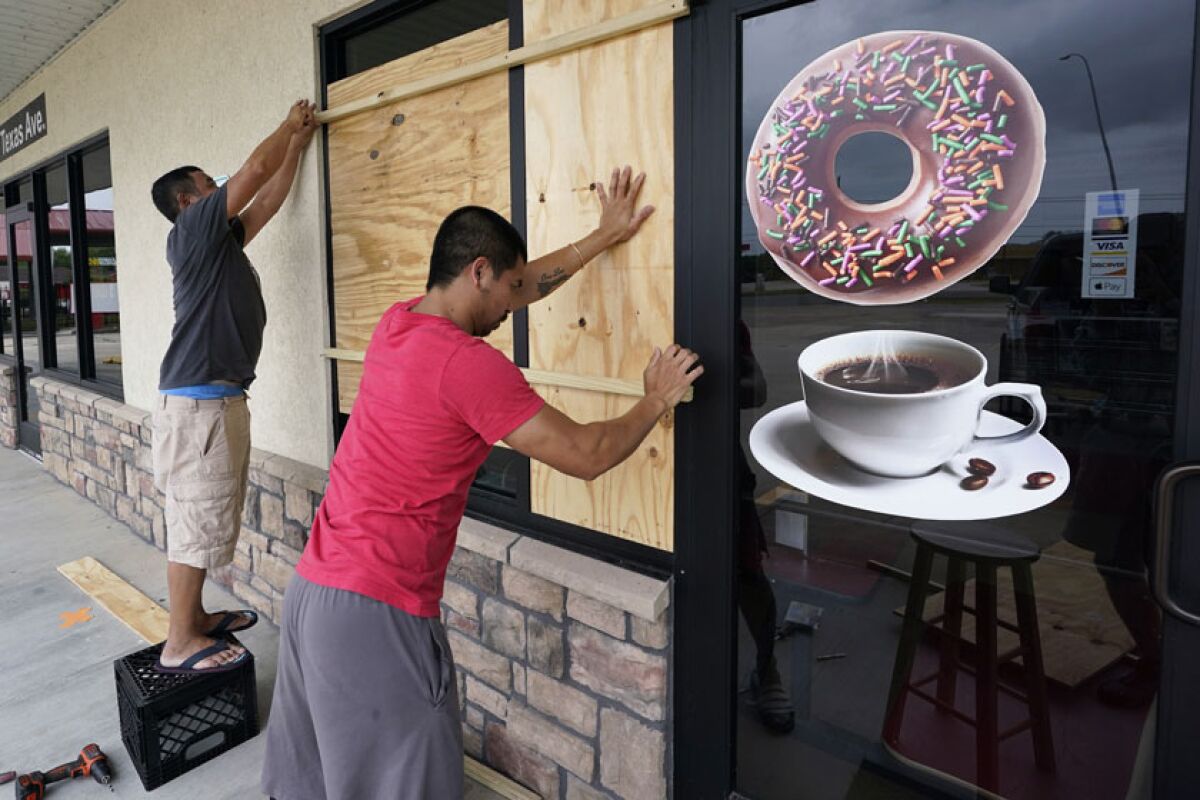 Daoith Porm, right, and Bunsant Khov board up their business in Bridge City, Texas, on Wednesday.